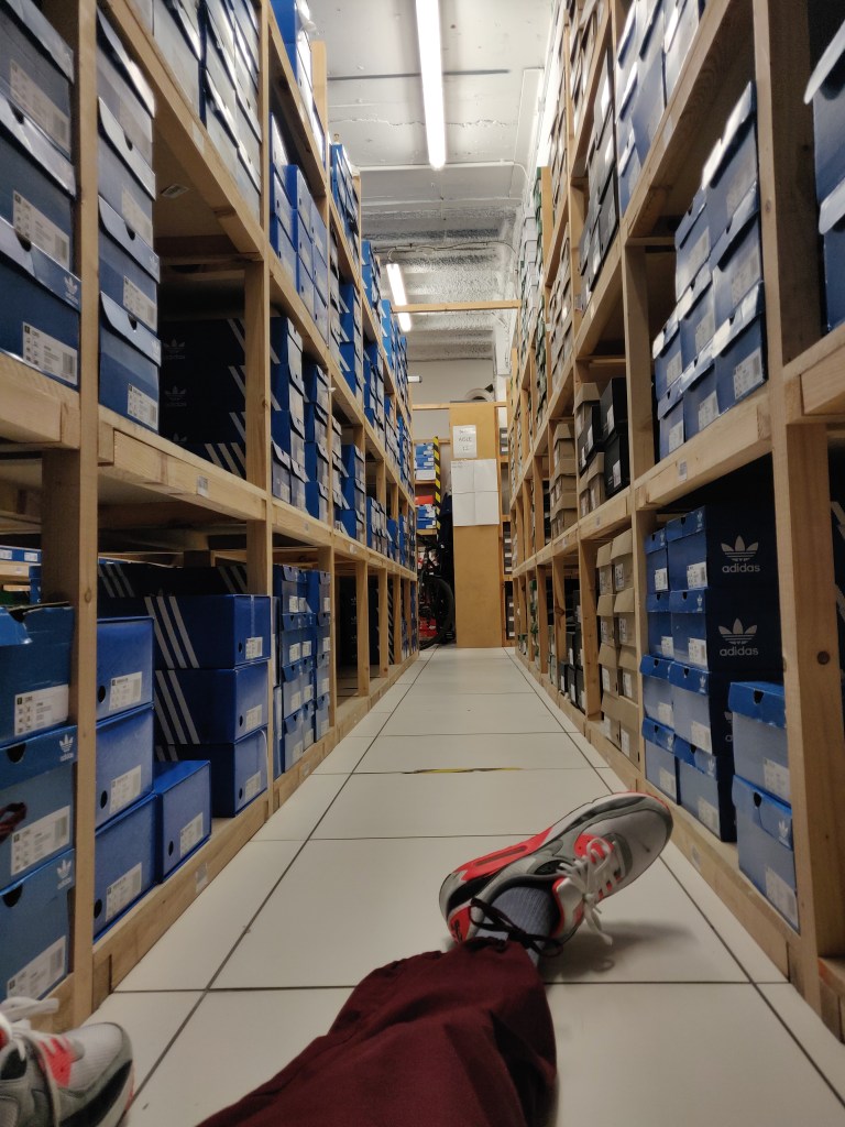 taking a rest in a stockroom full of adidas trainers while wearing the air max 90 Infrared 2020 edition and ACG burgundy zip-off cargos from the 2019 Season