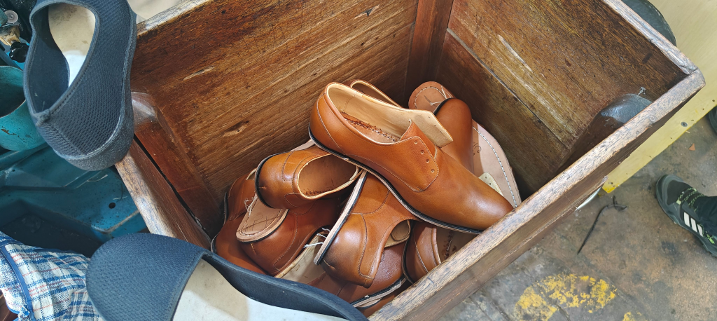 brown formal footwear uppers ready to be machine stitched onto sole unit in peruvain footwear market