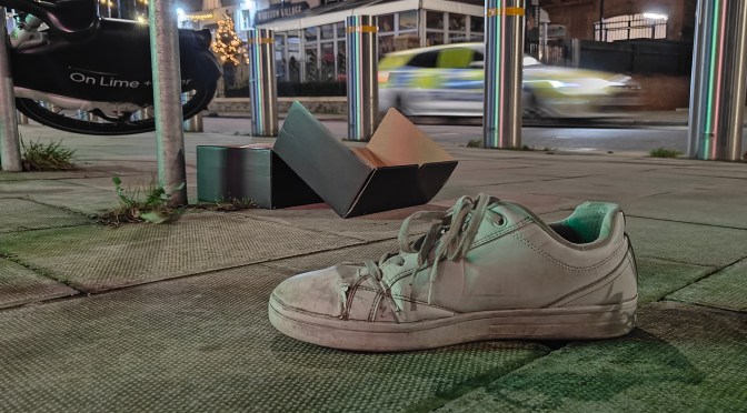 abandoned shoe in london with police car in the background