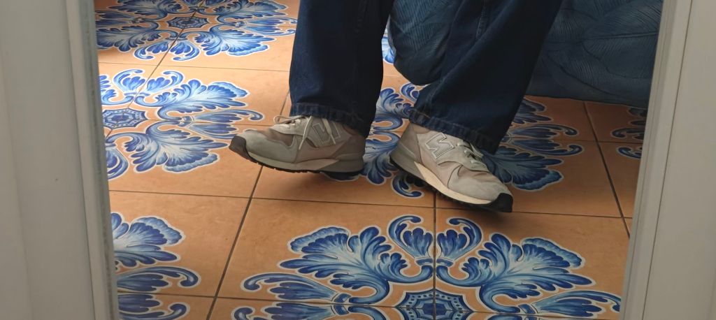 New Balance 475 on feet against some decorative tiles in Salerno