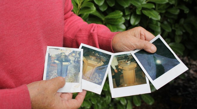 Inventor John Mott holding polaroid images of ASICS display unit that showcased the huge abilities of piezoelectric technology within footwear