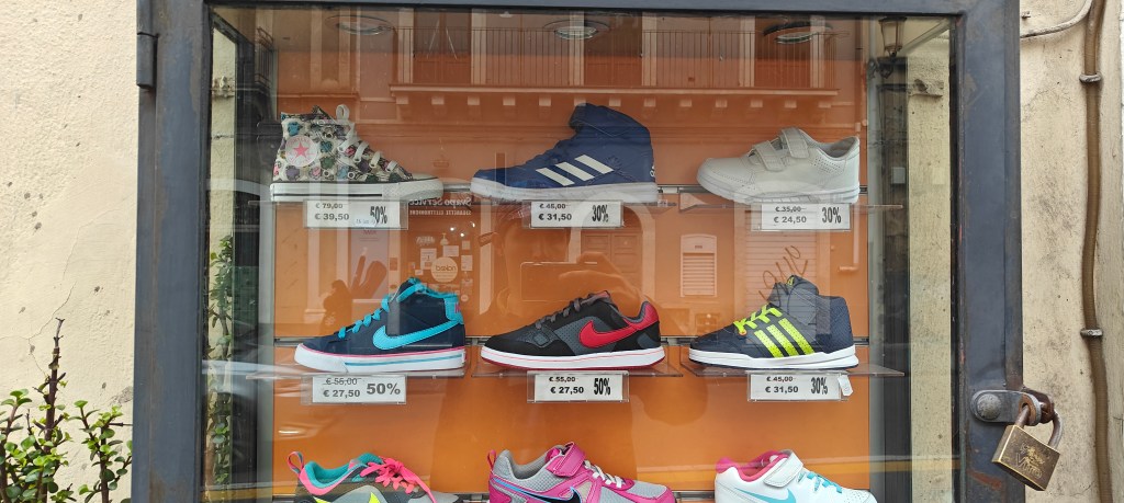 outside glass display unit adidas and nike shoes in catania sicily via etnea