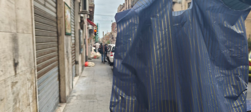 holding shopping bag up after shopping in catania's area sport 405