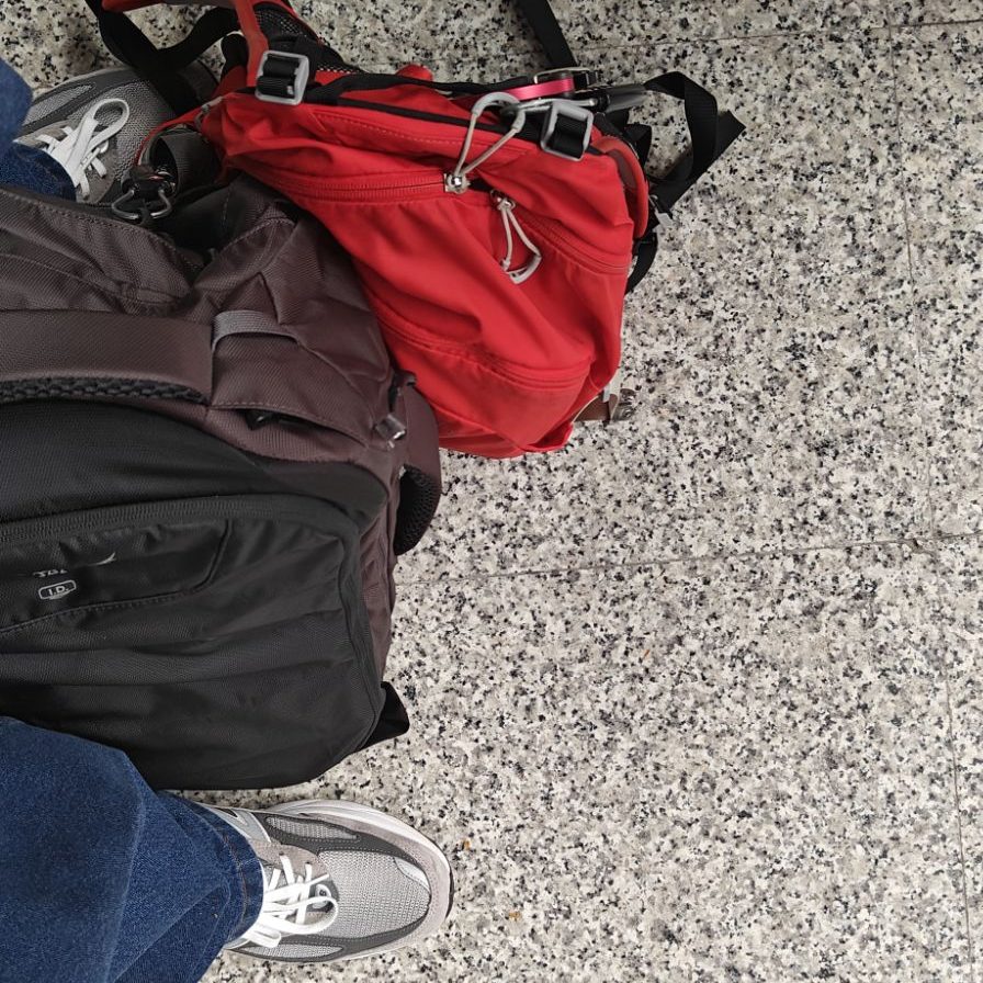new balance 990v6 holiday shoes next to backpacking set-up valencia train station floor