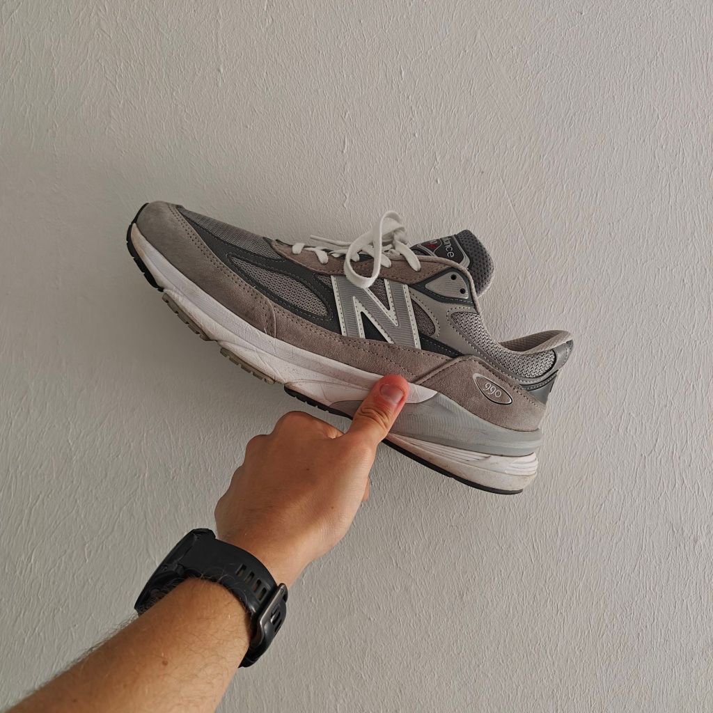 NB 990v6 pinned up against white wall with hand
