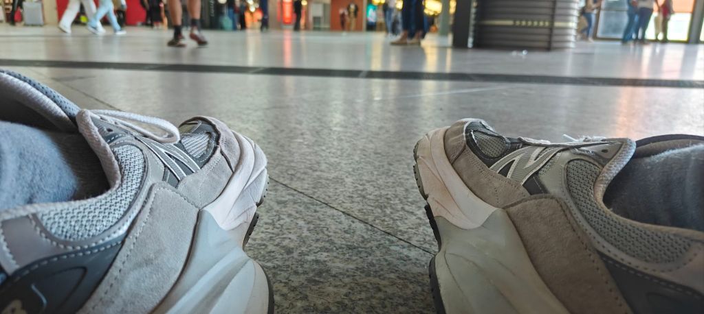 wearing the new balance 990v6 at the train station in madrid