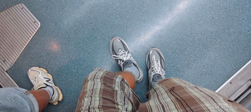 new balance 990v6 top down shot on the barcelona metro paired with plaid shorts