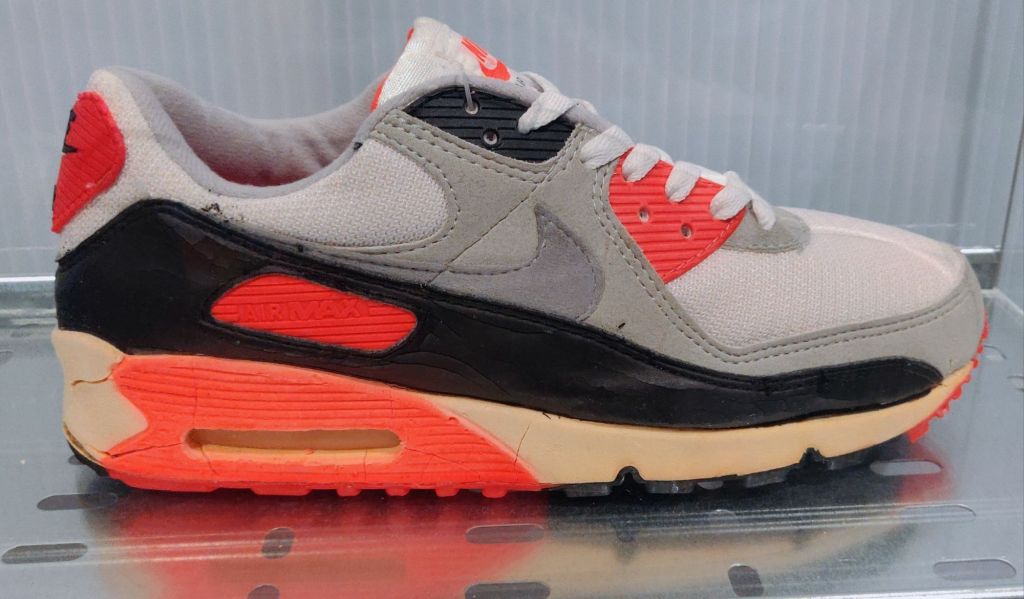 air max 90 infrared from 1990 on display glass protector side profile with cracked midsole by the heel